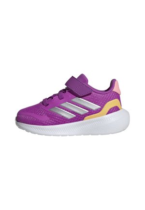 Zapatillas deportivas moradas con rayas plateadas, una correa de gancho y bucle, y una parte superior de malla texturizada. Acentos amarillos y rosas sobre una suela blanca.