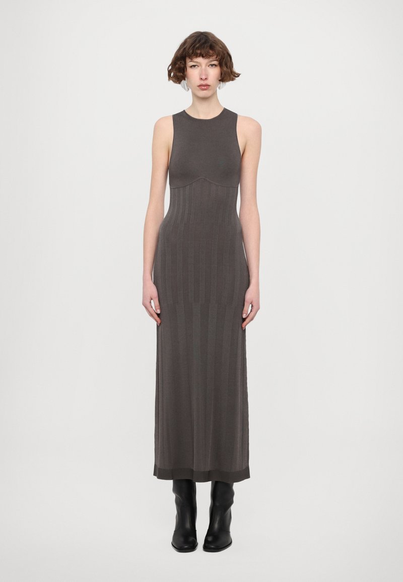 Knit maxi dress in dark gray with a fitted bodice, ribbed texture, and a straight silhouette, paired with ankle-length black boots.