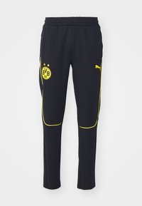 Zwarte sportieve broek met gele bies, Borussia Dortmund-logo op de linker dij, en Puma-logo op de rechter dij, elastische tailleband.