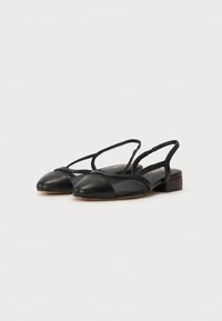 Chaussures noires à bride arrière avec un bout arrondi, dotées d'un cap en cuir, d'un corps en maille et de fines sangles. Design à petit talon carré.
