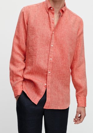 Koraalrood linnen shirt met een button-down kraag, lange mouwen en een lichtjes gestructureerde afwerking. Voorzien van een rechte zoom en witte knopen.