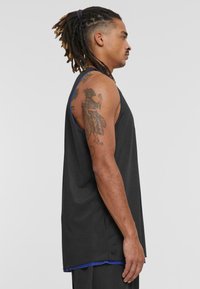 Svart mesh atletisk tanktopp med blå detaljer, med løs passform, ermeløs design og pustende tekstur.