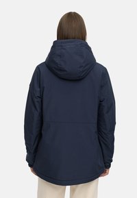 Mörkblå isolerad jacka med huva, med en slät yta och elastiska ärmar, designad för komfort och värme i kallt väder.