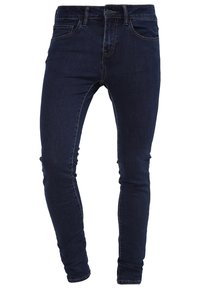 Tmavě modré skinny džíny vyrobené z denimu, s pěti kapsami, předním zipem a stehy podél švů.