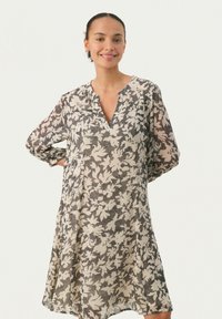 Langärmliges, knielanges Kleid in Creme mit einem schwarzen Blumenmuster. Verfügt über einen V-Ausschnitt und geraffte Ärmel, aus leichtem Stoff gefertigt.