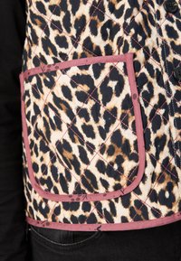 Κασκόλ με επένδυση σε σχέδιο λεοπάρ, σε καφέ και μαύρο, με τσέπη σε ροζ περίγραμμα και μαύρα κουμπιά.