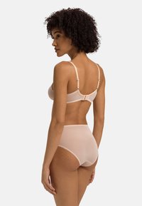 Set di lingerie nuda composto da un reggiseno liscio e senza cuciture con spalline regolabili e un paio di culotte alte e trasparenti.