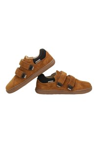 Bruine suède kindersneakers met twee klittenbandsluitingen, een zwarte hielkraag en rubberen zolen, getoond vanuit zijhoeken op een witte achtergrond.