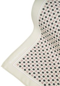 Jasna kremowa chusta z tkaniny z powtarzającym się wzorem czarnych kwiatów i czerwonych kropek, z cienką różową obwódką oraz brandingiem "Pako Lurente".