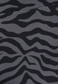 Gray fabric featuring a wavy black zebra stripe pattern. Smooth texture with a slight sheen, uniform shape, and no visible hardware or closures.