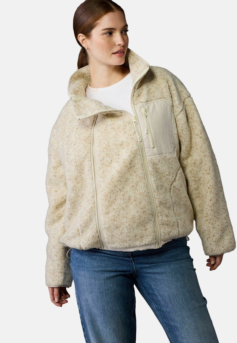 Krémovo sfarbená fleece bunda s vysokým golierom, zipsom na prednej strane a textúrovaným vzorom. Obsahuje bočnú vrecko a uvoľnený strih.