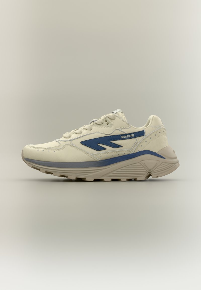 Balts sporta apavu pāris ar zilām detaļām, teksturētu ādas augšdaļu, polsterētu apkakli un bieza, ribota zole, kas nodrošina labu saķeri.