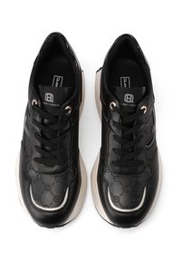 Sneakers neri realizzati in materiali lisci e testurizzati, caratterizzati da intricati motivi monogramma, punta rotonda e suola beige. Design con lacci.