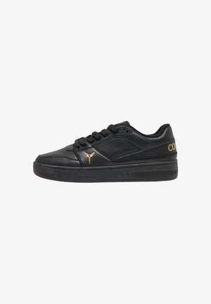 Baskets basses en cuir noir avec lacets noirs, logo ailé doré sur le côté, et marquage "Colucci" en or sur le talon et la semelle.