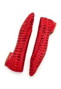 Ballerine rosse intrecciate con design aperto, caratterizzate da una punta affusolata e un tacco quadrato basso. Materiale testurizzato con dettagli intricati di intrecci.