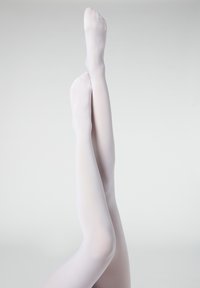 Pantys blancos, semitranslúcidos, mostrados con las piernas elevadas, con una textura suave y un ajuste ceñido, que destacan las formas naturalmente contorneadas.