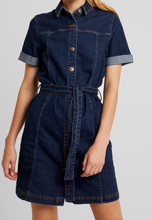 Robe en jean bleu foncé avec manches courtes retroussées, devant boutonné et une ceinture. Caractérisée par des coutures contrastantes et une taille cintrée.