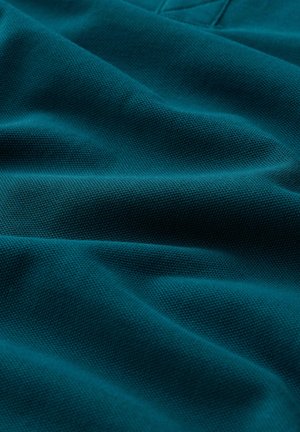 Sinine-rohelise tekstuuriga kangas peente lainetega, näidates lähedalt kudumi detaile ja pehmeid voldikuid.