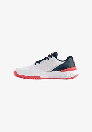 Zapatilla deportiva blanca con un upper texturizado, acentos en color azul marino y suela roja. Presenta un material transpirable y un sistema de cordones tradicional.