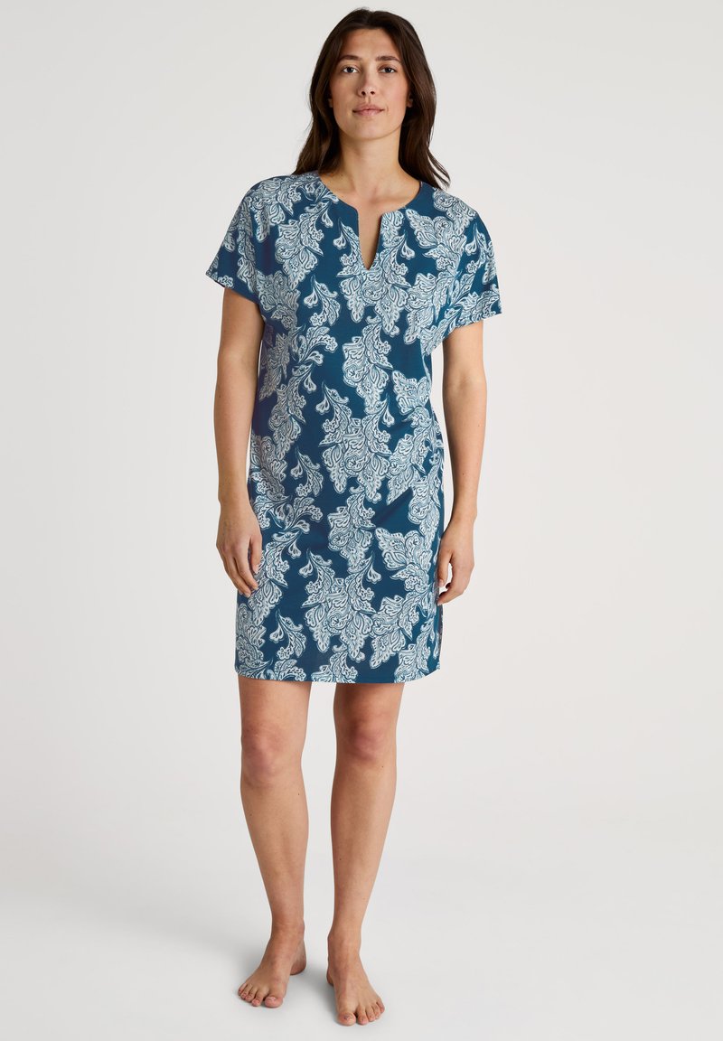 Kortdurige teal jurk met een wit paisleypatroon en een V-hals, gemaakt van lichtgewicht stof met een relaxte pasvorm.