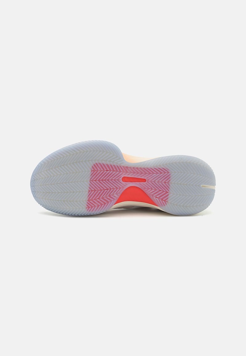 Semelle de chaussure de basketball, avec un caoutchouc bleu translucide arborant un motif en chevrons et un accent rouge vif au niveau de la semelle intermédiaire.