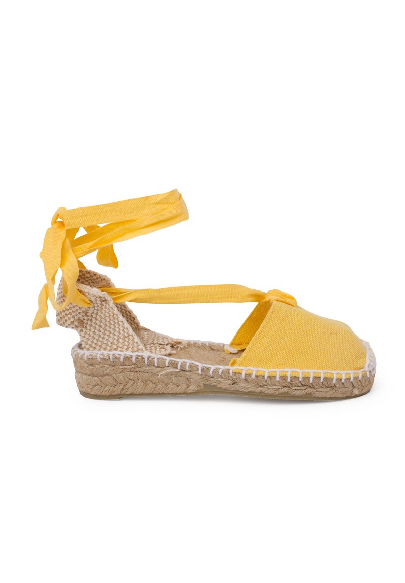 Espadrillas gialle con tomaia in tela, suola in juta intrecciata e lacci alla caviglia. Presentano una punta arrotondata e dettagli in cucitura bianca lungo la suola.