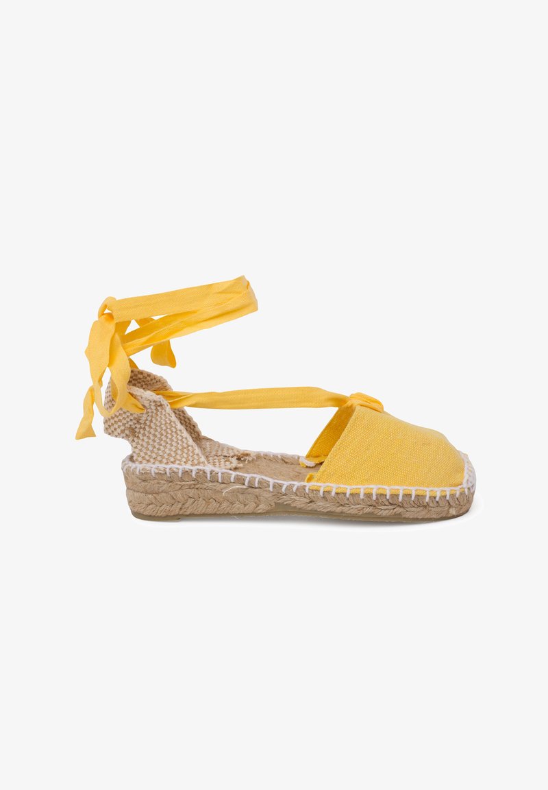 Espadrillas gialle con tomaia in tela, suola in juta intrecciata e lacci alla caviglia. Presentano una punta arrotondata e dettagli in cucitura bianca lungo la suola.
