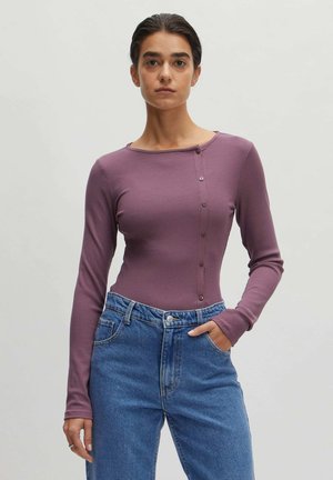 Paarse ribbel top met lange mouwen, voorzien van een ronde halslijn en een knoopsluiting aan de linkerkant, gecombineerd met hoge taille blauwe jeans.