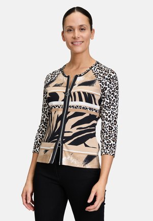 Veste zippée avec des manches léopard trois-quarts, présentant un corps de teinte neutre avec des motifs animaliers abstraits et métalliques.