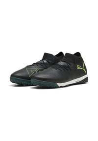 Botas de fútbol negras con un upper texturizado, acentos verdes y una mediasuela blanca. Presentan un ajuste ceñido y una suela de goma para tracción.