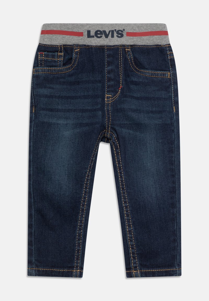 Jean en denim bleu foncé avec une taille élastique grise ornée de lettres rouges. Comprend des poches avant et des détails de couture jaunes.