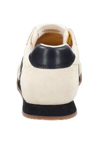 Bílé semišové tenisky s černou koženou patou a bočními akcenty, s texturovaným povrchem a gumovou podrážkou.