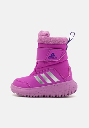 Botte étanche rose avec un col en fourrure, sangle velcro, accents argentés et semelle texturée présentant un design moucheté.