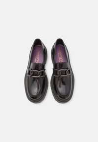 Paire de mocassins en cuir noir brillant avec détail chaîne épaisse et semelles en caoutchouc épaisses, semelles intérieures violettes estampillées Marc O'Polo.