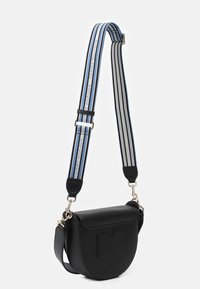Černá kožená crossbody taška zaobleného tvaru, která má přední kapsu a pruhovaný ramenní popruh v modré, šedé a černé barvě. Stříbrné kovové doplňky.
