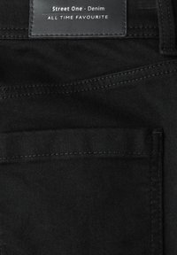 Černá denimová látka s kontrastním stehováním, kožená nášivka s názvem značky a detail přední kapsy.