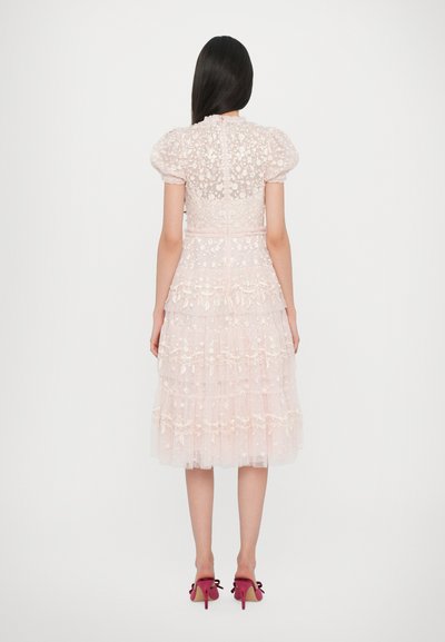 Tulle midi-jurk met een aansluitend lijfje, pofmouwen, geborduurde bloemdetails en een gelaagde ruche rok in zachte roze tint. Met ritssluiting aan de achterkant.