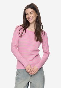 Roze longsleeve met horizontale lichtroze strepen. Zachte stof, ronde hals, aansluitende pasvorm, eenvoudig ontwerp. Draagt leuk bij casual spijkerbroeken.