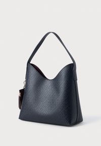 Granatowa torebka na ramię, wykonana z teksturowanego materiału, o wyraźnej formie i pojedynczym uchwycie, z małą zasuwaną kieszonką akcentującą.