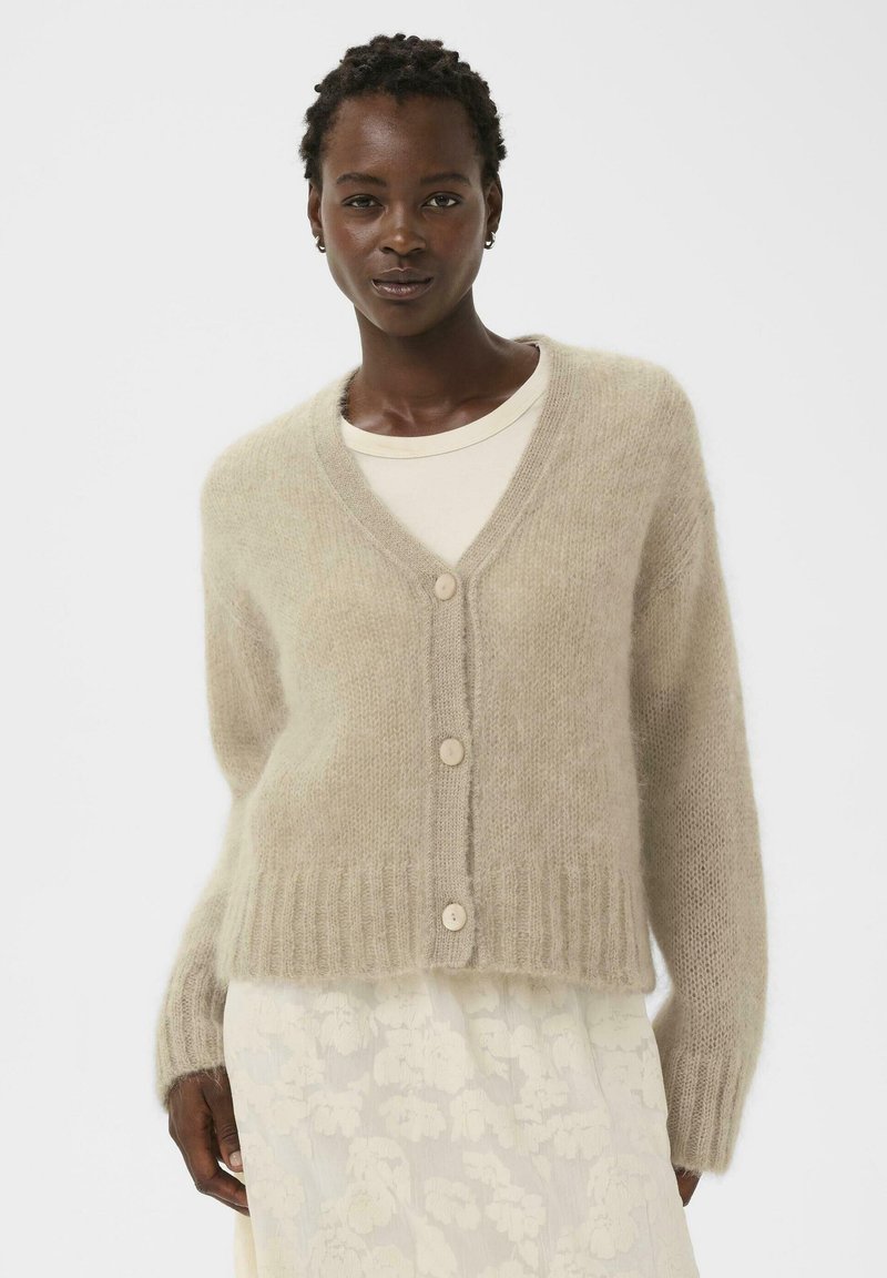 Beiger Cardigan aus weichem, strukturiertem Strickstoff mit V-Ausschnitt, langen Ärmeln und vier cremefarbenen Knöpfen an der Vorderseite.