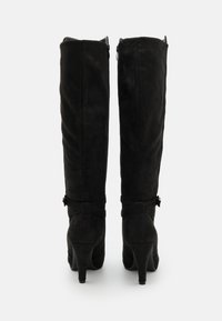 Black knee-high boots with a smooth suede texture, tapered shape, and a high heel. Features a small bow accent at the ankle and a side zipper.