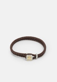 Bracciale in pelle intrecciata marrone con chiusura in argento e un accento quadrato dorato con logo. Texture liscia, design minimal.