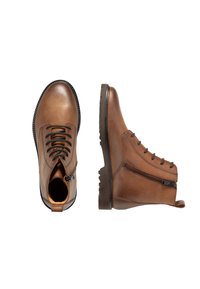 Botines de cuero marrón con cordones, cremallera lateral y suelas texturizadas. Acabado liso con costuras en contraste y una cinta para tirar.