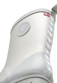 Witte rubberen regenlaars met een circulair logo, verhoogd gestreept patroon en een klein Deens vlagdetail nabij de bovenkant. Getextureerde zool.