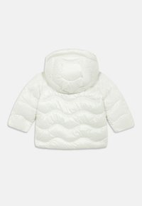 Casaco tipo puffer branco com capuz, apresentando um padrão de ondas acolchoadas e mangas curtas. Textura suave com um acabamento brilhante.