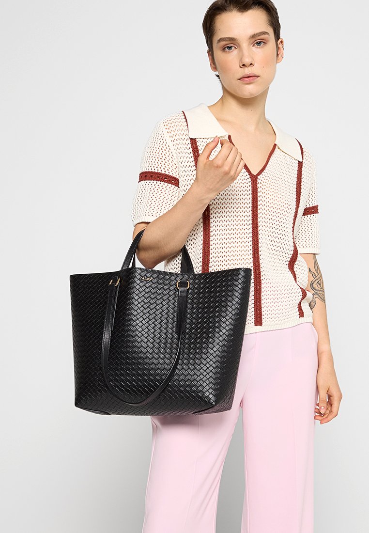 Borsa tote nera intrecciata con forma strutturata, dotata di due manici e dettagli in hardware tono oro. Texture in pelle liscia.