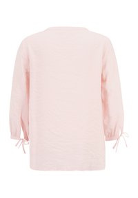 Haut à manches longues, en mélange de coton rose clair, avec une coupe ample, un col rond et des poignets noués. Présente une finition légèrement texturée.