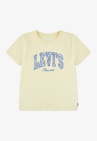 Ανοιχτό κίτρινο κοντομάνικο μπλουζάκι με μπλε κείμενο «LEVI'S Since 1873» και μικρές λευκές ανθισμένες λεπτομέρειες στο μπροστινό μέρος.