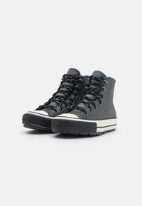 Zwarte high-top sneakers met een glad leren bovenwerk, een gestructureerde rubberen zool, een witte middenzoolstreep en zwarte veters.