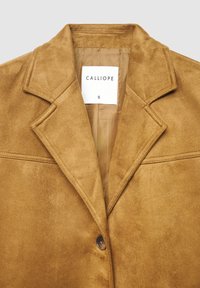 Veste en daim marron avec col cranté, fermeture à bouton unique et doublure intérieure lisse. L'étiquette indique "CALLIOPE", taille S.